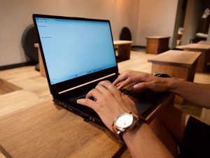 Person typing on a laptop keyboard to issue or verify a digital credential in a text-editor interface.