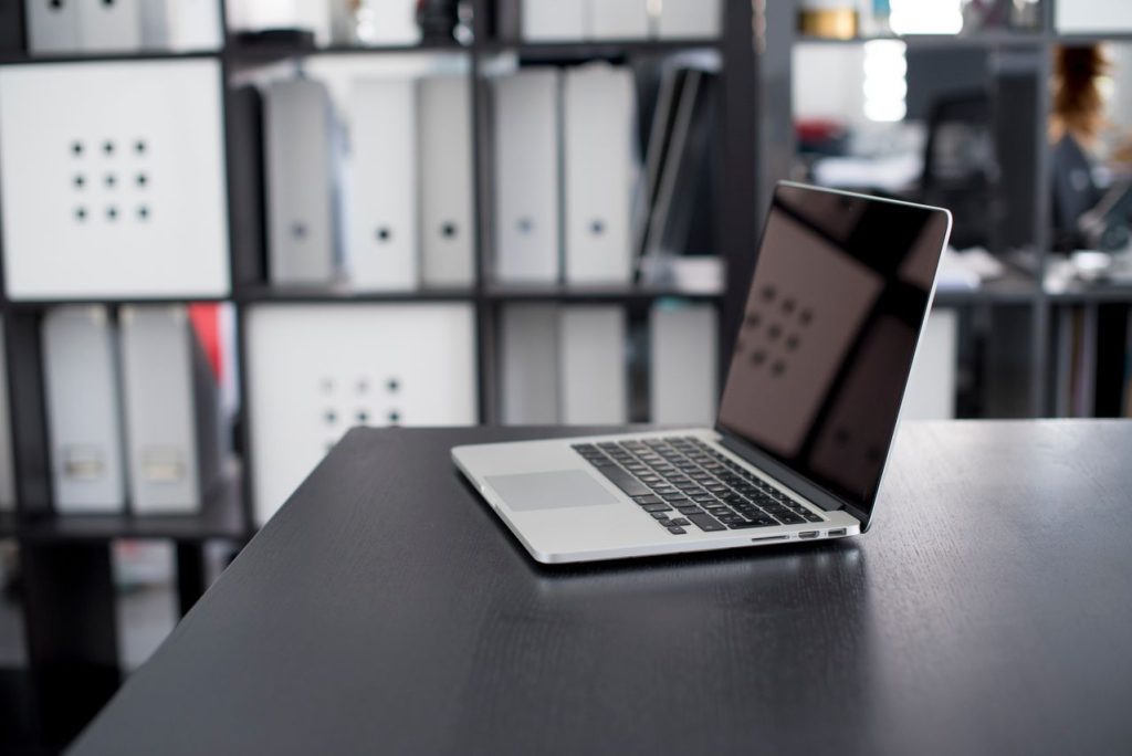 An open laptop on a dark desk representing digital online speaking practice and AI feedback.