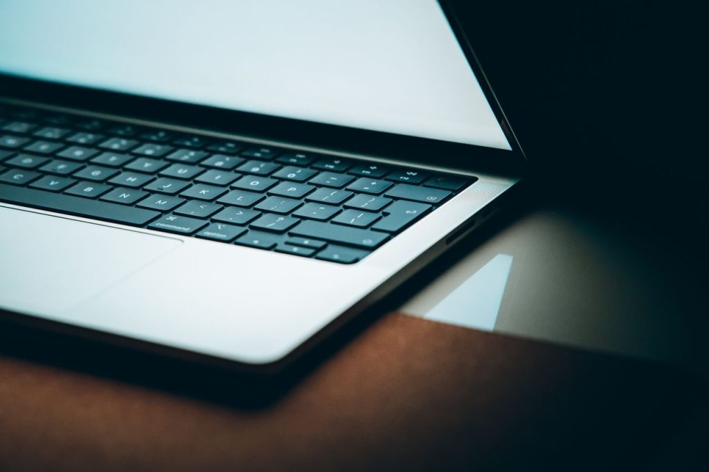 Close-up of a laptop keyboard and bright screen used for processing commercial lease PDFs into structured data for accounting software.