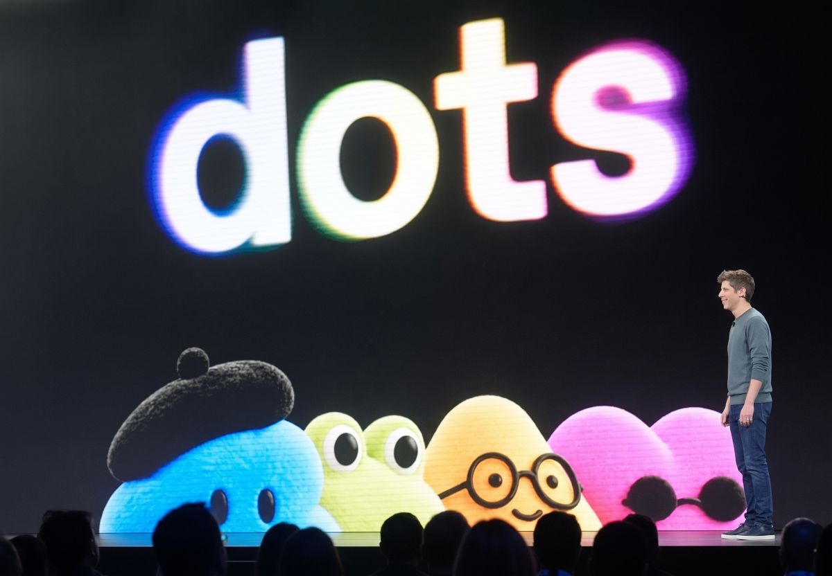 Altman presenting OpenAI Dots on stage at DevDay with colorful character avatars under a large illuminated "dots" logo.